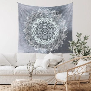 Détail de la texture d'une tapisserie mandala bohème suspendue dans un salon minimaliste