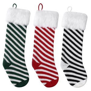 Three striped knitted Christmas stockings in green, red, and black with faux fur cuffs