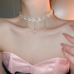 Detail of beaded choker featuring three delicate metallic hanging chains with clear beads