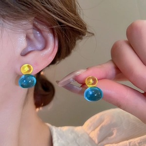 Detail of translucent yellow and blue bead earrings showing the elegant glass texture