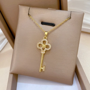 Close-up of golden titanium steel star cross key necklace with crystals in a jewelry box