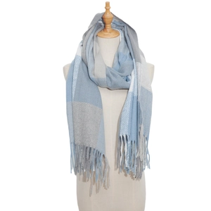 Macro detail of plaid scarf fabric texture and long tassels in blue, grey and white