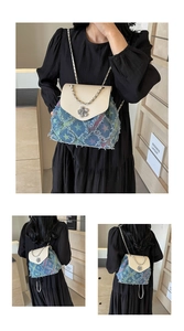Detail of star embroidery on denim bucket bag with leather flap and silver chain
