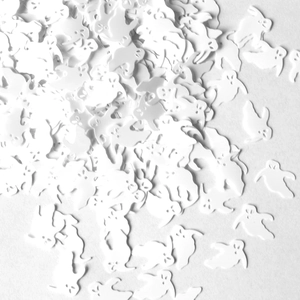 Close-up of white ghost-shaped sequins for Halloween party table decoration