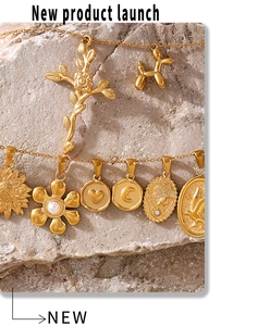 Close-up of assorted 18K gold plated geometric pendants including balloon dog and sunflowers