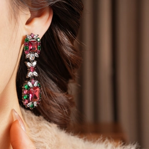 Close-up of vintage drop earrings with red square stones and multi-color crystals