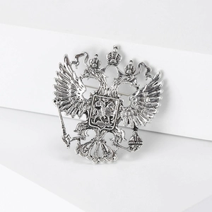 Close-up of antique silver double-headed eagle brooch with intricate embossed details