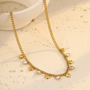 Detailed close-up of golden heart pendant necklace on natural stone surface