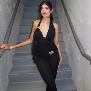 Detail of black halter top and slim flare pants set showing stretch fabric texture