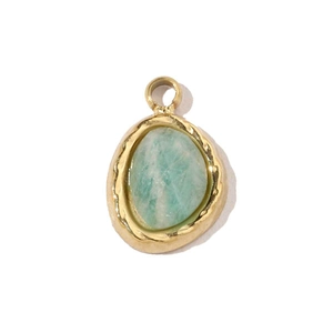 Vue macro d'un pendentif en pierre naturelle vert clair avec serti en acier doré