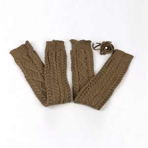 Close-up of brown knit leg warmer showing vintage cable pattern and hollow-out detail