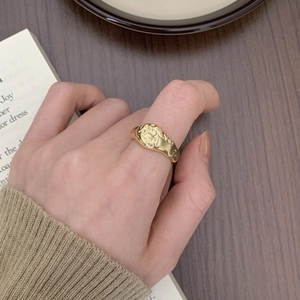 Close-up of a 925 silver irregular gold ring with vintage relief on a female hand