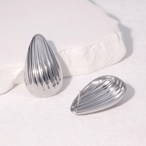 Vue détaillée de boucles d'oreilles argentées en forme de goutte avec motif rayé