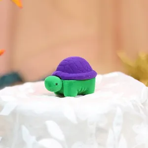 Detail of cute turtle-shaped velvet jewelry box in green and purple for rings and earrings