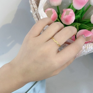Close-up of a gold-plated S925 silver wavy ring worn on a finger with tulip background