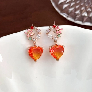 Macro view of floral butterfly earrings with heart pendant and gradient color zircon