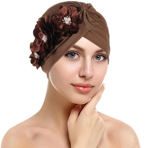 Detail of dark brown turban hat featuring three handmade silk flowers and pearl accents