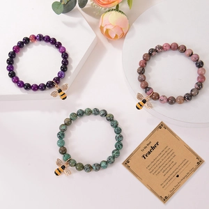 Detailed view of natural agate bead bracelets with golden bee charms and gift card