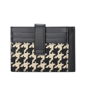 Slim houndstooth and black leather card holder with four slots and a snap fastener