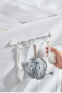 Detail of adjustable wall-mounted rail with movable S-hooks for kitchen and bathroom storage