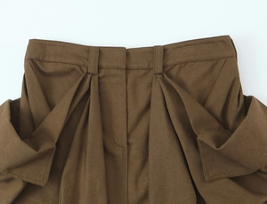 Detailed view of dark khaki cargo skirt waist featuring pleated design and twill texture