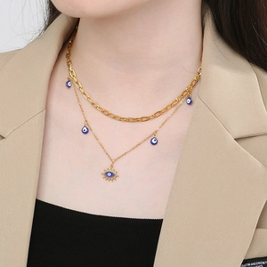 Gros plan d'un collier doré double épaisseur avec pendentifs œil bleu sur un mannequin