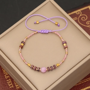 Detail of handmade bohemian beaded bracelet featuring purple natural stone on display