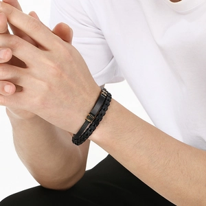 Detail of double-layer black braided leather bracelet with a sleek black metal plate