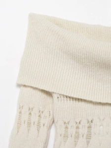 Close-up of white ribbed knit fabric with delicate pointelle hollowed-out patterns