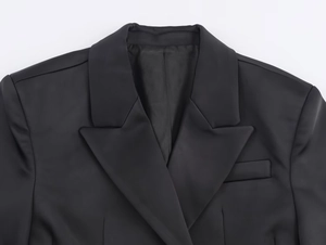 Dettaglio del rever e del taschino su questo set blazer nero satinato lucido