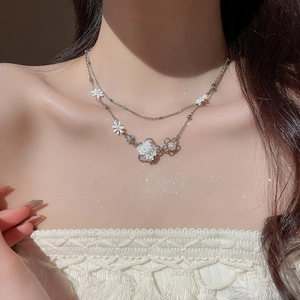 Close-up of double-layer silver flower necklace with pearls worn on model neck
