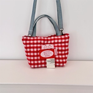 Detail of red gingham plaid wool tote with embroidered patch and blue denim strap