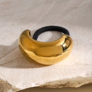 Elegant gold curved stainless steel hair cuff with black elastic tie on textured stone