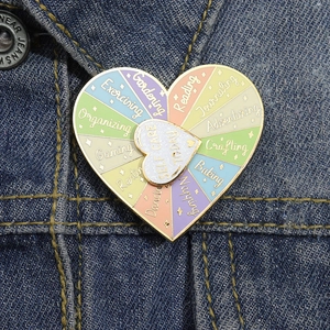 Dettaglio di una spilla rotante in smalto a forma di cuore su giacca di jeans blu
