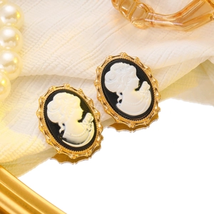 Macro shot of vintage cameo earrings with golden frames and portrait design