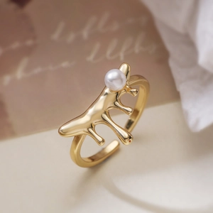 Irregular 18K gold plated lava ring with a white pearl on a vintage paper background