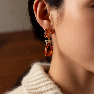 Vue détaillée de boucles d'oreilles vintage avec pendentif goutte orange sur modèle
