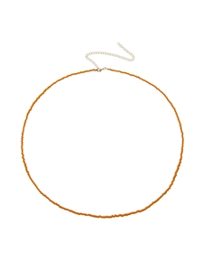 Detail of bohemian orange seed bead body chain with adjustable golden metal clasp