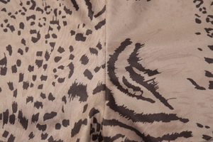 Gros plan sur tissu beige avec motif léopard marron foncé et coutures détaillées