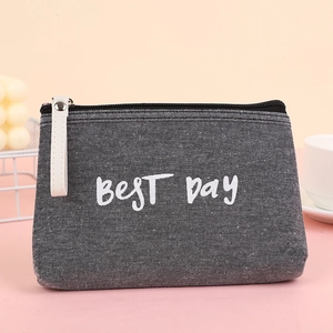 Portable dark grey denim makeup bag with BEST Day lettering and white zipper pull