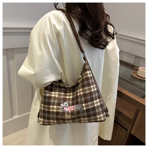 Brown checkered shoulder bag with dachshund embroidery shown on a model's shoulder