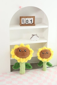 Gros plan de peluches tournesols avec visages souriants sur un tapis à carreaux