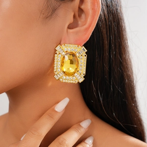 Boucles d'oreilles vintage dorées avec pierres jaunes et diamants portées par un mannequin
