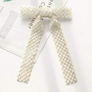 Detail of white bow hair clip with silver tube bead embroidery and elegant long tassels