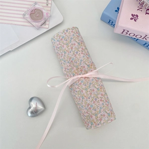 Top view of floral fabric rolls tied with pink ribbon for makeup bag sewing