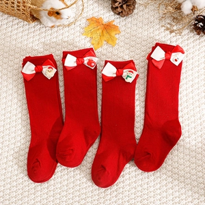 Set of four red cotton Christmas baby socks with festive 3D cartoon bows and knit texture