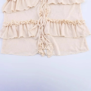 Elegant apricot knit top featuring layered ruffle details and front tie-up design