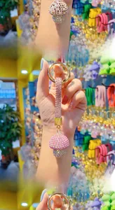 Detailed close-up of sparkling crystal-encrusted mushroom keychain in pink and purple tones