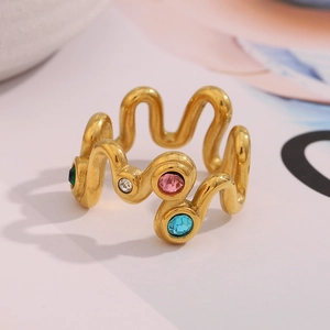 Close-up of 18K gold plated wave ring with colorful pink, blue, and green gemstones
