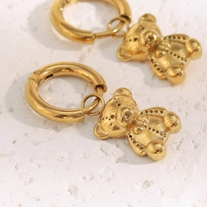 Macro shot of gold-plated stainless steel bear earrings with textured bear pendants